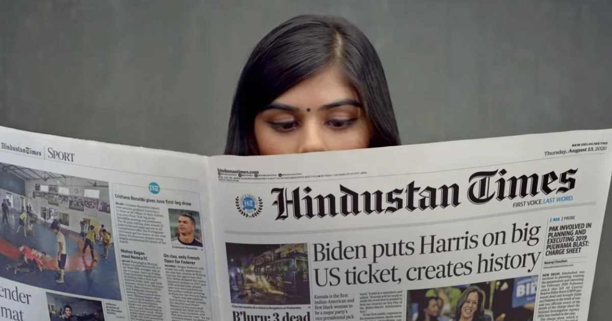 A reader with the Hindustan Times, open at the advertisement pages
