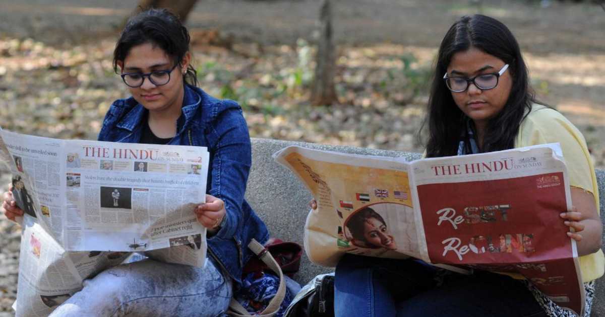 Two readers with copies of The Hindu